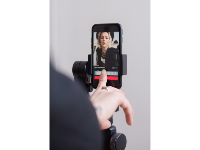 Fotografía de una joven grabándose con su móvil a través de un vídeo de TikTok.