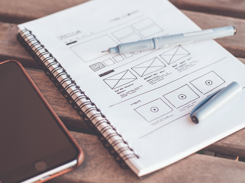 An open notebook showing the design sketch of a web user experience in Marbella